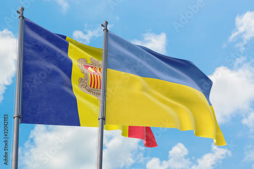 Ukraine and Andorra flags waving in the wind against white cloudy blue sky together. Diplomacy concept, international relations.