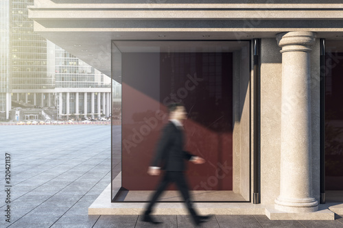 Businessman walking near blank shop window. © Who is Danny