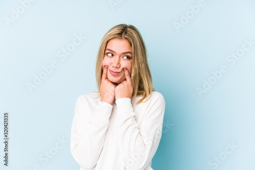Young blonde caucasian woman isolated doubting between two options.