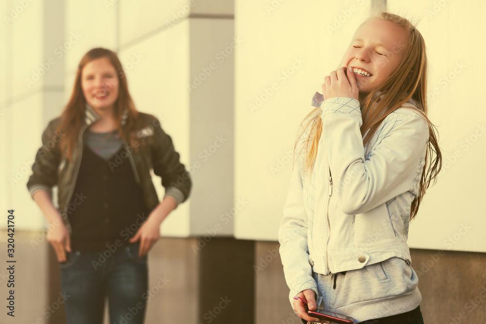 Happy teen girls laughing on city street Happy teen girls laughing on city street