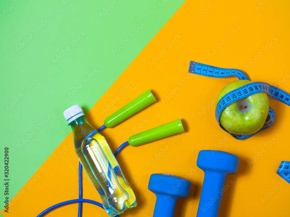 flat lay photo of fitness equipment over orange and green backgound. top view flat lay photo of fitness equipment over orange and green backgound. top view