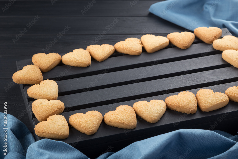 Heart shaped cookies decorated for Valentine's Day. Rectangular frame with heart shaped cookies on a black wooden table. Free space for text Heart shaped cookies decorated for Valentine's Day. Rectangular frame with heart shaped cookies on a black wooden table. Free space for text