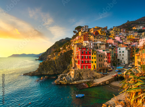 Riomaggiore town, cape and sea landscape at sunset. Cinque Terre, Liguria, Italy