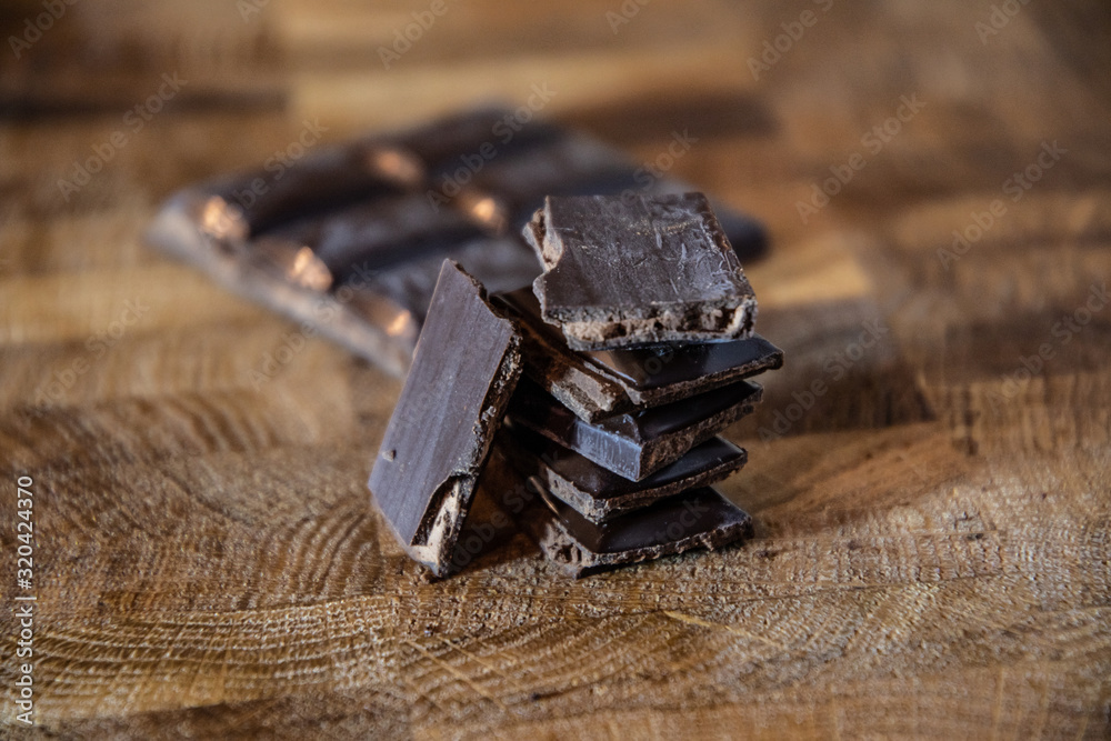 Dark chocolate with filling on a wooden table.