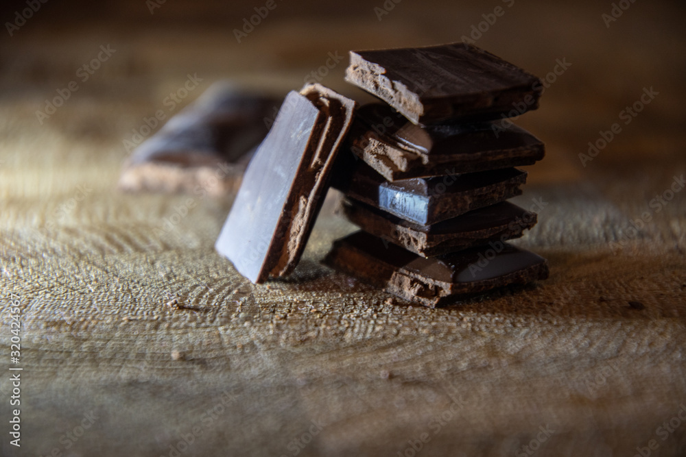 Chocolate pyramid from the pieces of chocolate with filling on a wooden table. Chocolate pyramid from the pieces of chocolate with filling on a wooden table.