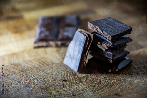 Slices of black chocolate with filling on wooden boards.