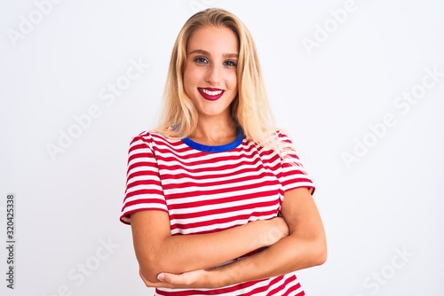 Young beautiful woman wearing red striped t-shirt standing over isolated white background happy face smiling with crossed arms looking at the camera. Positive person.