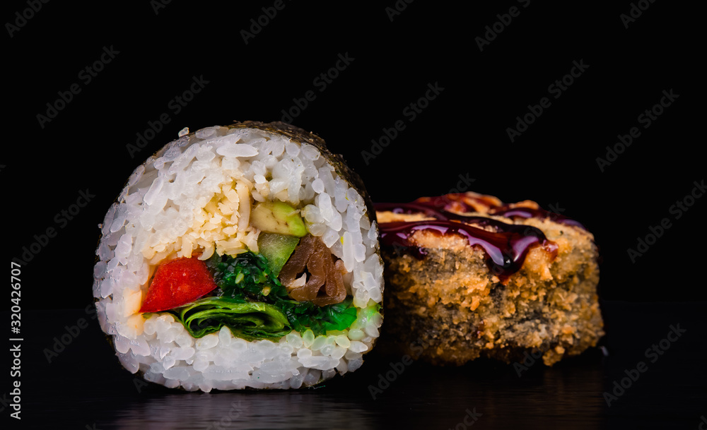 Traditional fresh japanese sushi rolls on a black background. Deep Fried Sushi. Traditional fresh japanese sushi rolls on a black background. Deep Fried Sushi.