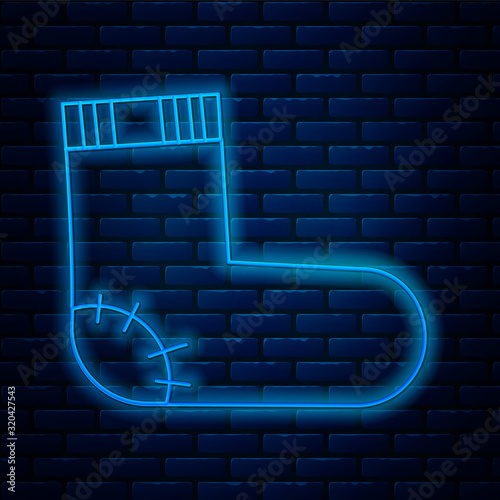 Glowing neon line Baby socks clothes icon isolated on brick wall background. Vector Illustration