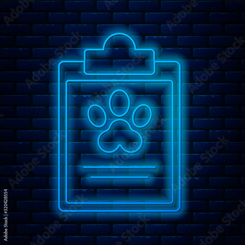 Glowing neon line Clipboard with medical clinical record pet icon isolated on brick wall background. Health insurance form. Medical check marks report. Vector Illustration