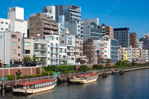 Japan. Tourist ferries off the coast of Tokyo. Buildings are located on the banks of the river. View of the city from Tokyo Bay. Architecture of Japanese cities. Ferries at berths in Japan.