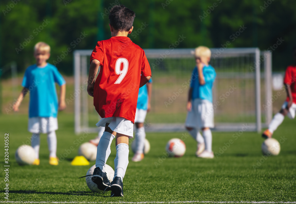 Children Training Soccer on Field. Young Kids Boys kicking Soccer Football Balls on Grass Pitch. Kids in Sportswear Practice Soccer Skills