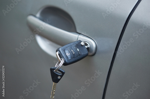 Man with car key. Opening car door. photo