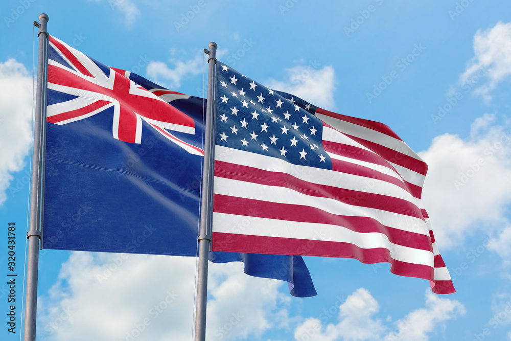 United States and Anguilla flags waving in the wind against white cloudy blue sky together. Diplomacy concept, international relations.
