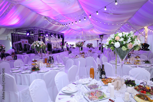 Wedding hall without guests with white chairs and decor in the outdoor wedding tent photo
