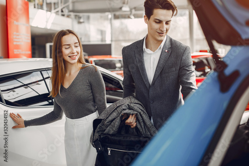 Couple buying the car. Pair in a car salon. Husband with vife choose the automobile photo