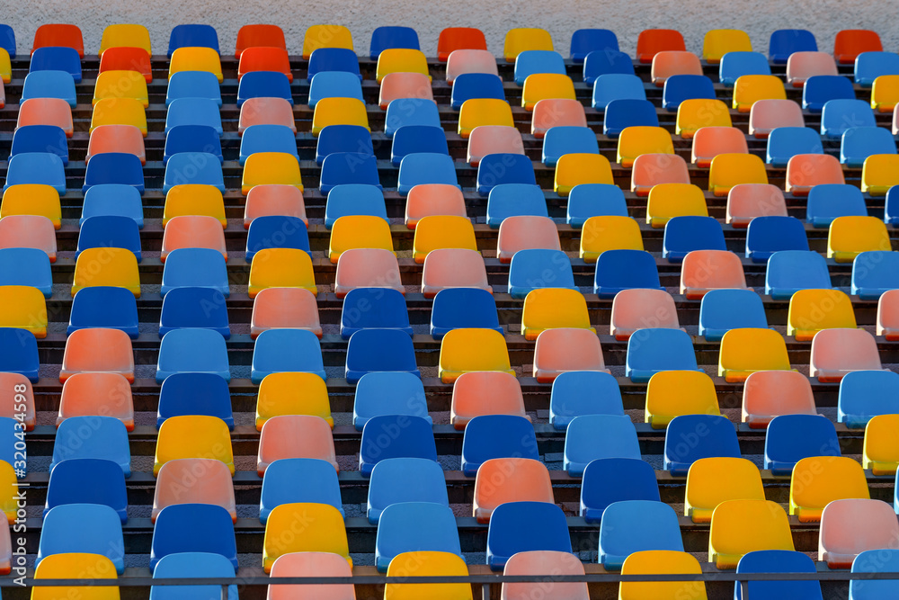 Fototapeta premium Blue and orange stadium plastic seats. Colorful texture
