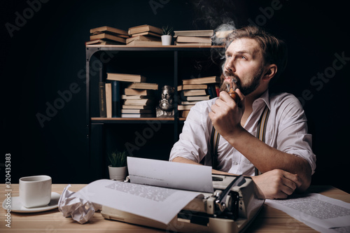 Handsome bearded writer thinking, smoking pipe and looking upwards