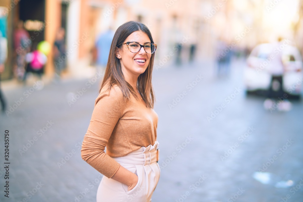 Young beautiful woman smiling happy and confident. Standing with smile on face at the town street