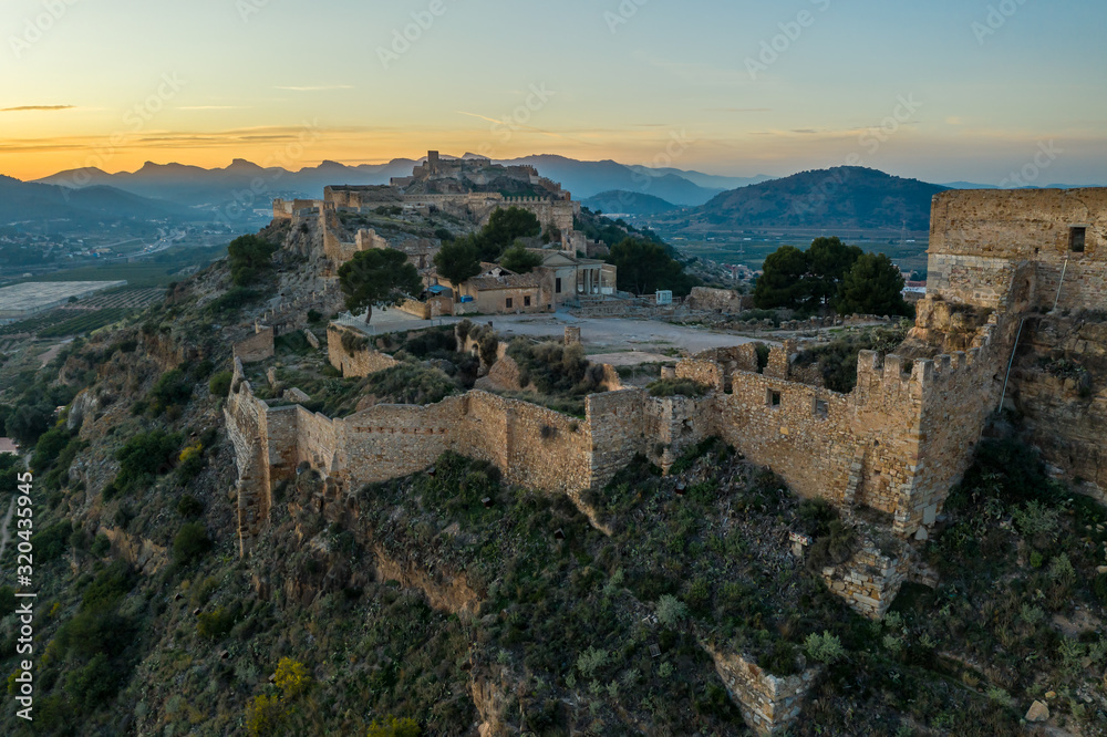 Aerial sunset view of Sagunto, huge fortress stretching across the mountain range north of Valencia Spain