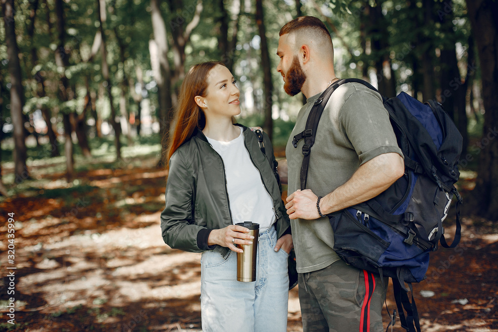 Tourists in a summer forest. Couple with a map. Tourists in a summer forest. Couple with a map.