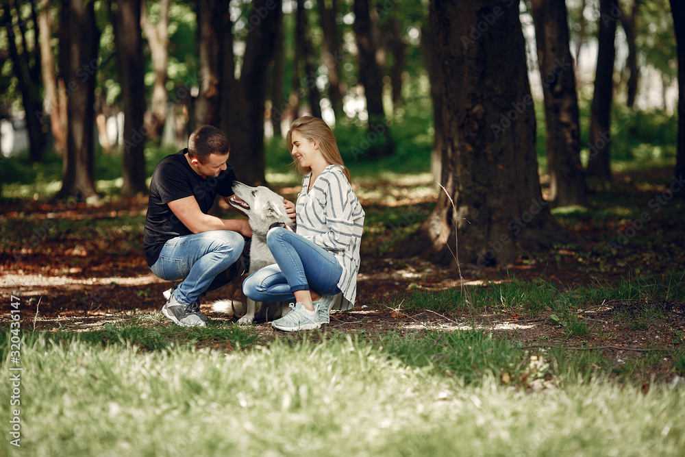 Couple in a forest. Pair playing with a cute dog