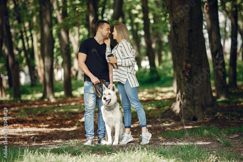 Couple in a forest. Pair playing with a cute dog