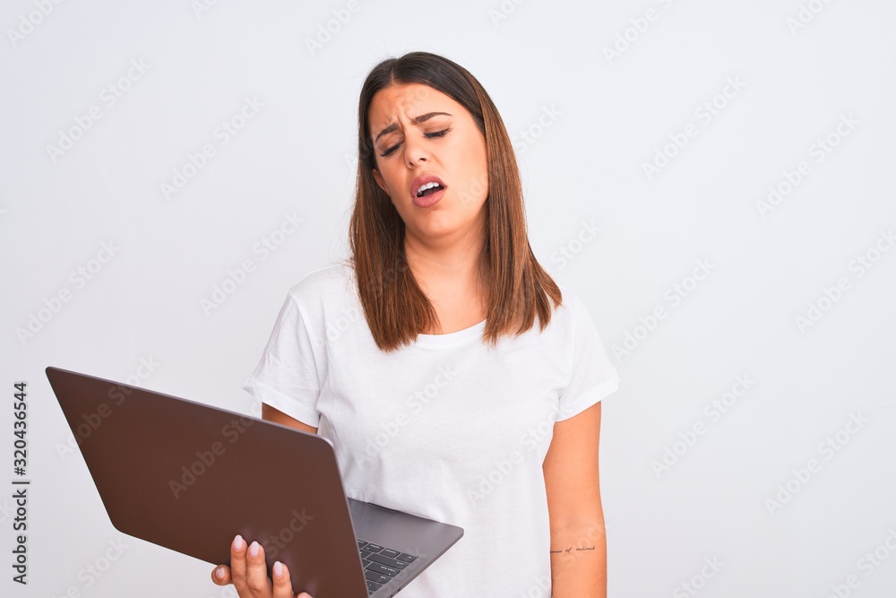 Beautiful young woman working using computer laptop over white background looking sleepy and tired, exhausted for fatigue and hangover, lazy eyes in the morning. Beautiful young woman working using computer laptop over white background looking sleepy and tired, exhausted for fatigue and hangover, lazy eyes in the morning.