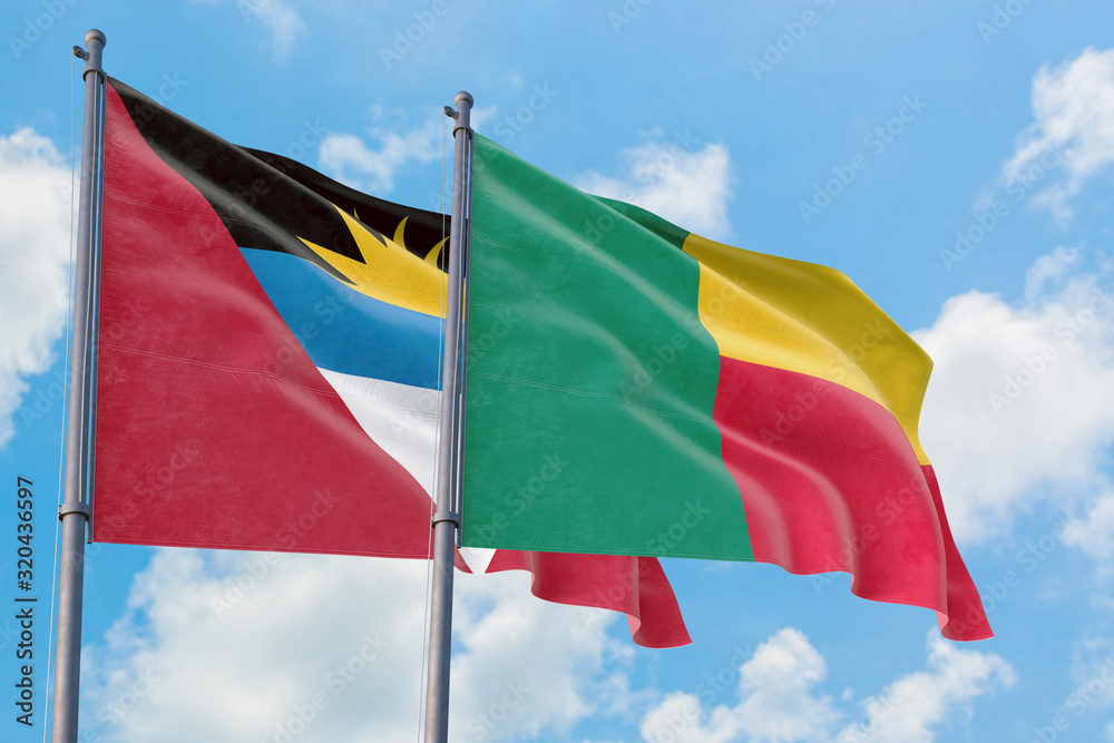 Benin and Antigua and Barbuda flags waving in the wind against white cloudy blue sky together. Diplomacy concept, international relations. Benin and Antigua and Barbuda flags waving in the wind against white cloudy blue sky together. Diplomacy concept, international relations.