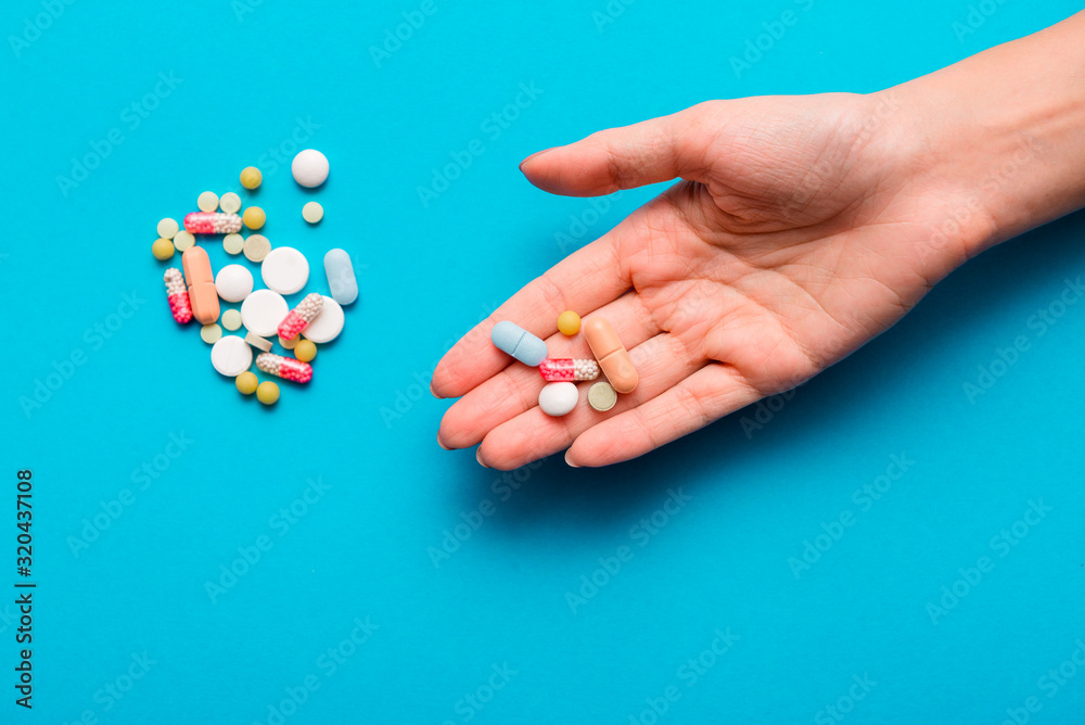 Pills in hands on a blue background.