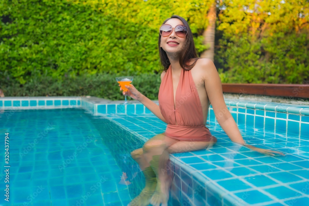 Portrait young asian woman relax happy smile around swimming pool in hotel