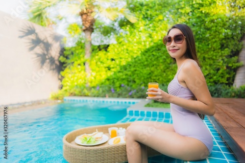 Portrait young asian woman happy smile enjoy with floating breakfast tray in swimming pool in hotel