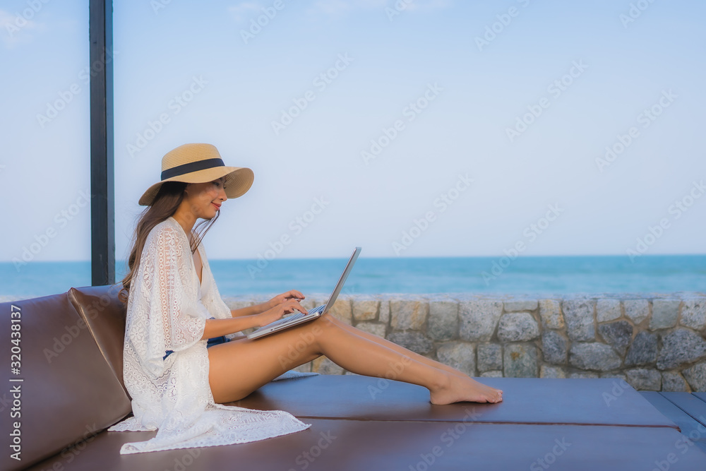 Portrait young asian woman using laptop computer around beach sea ocean