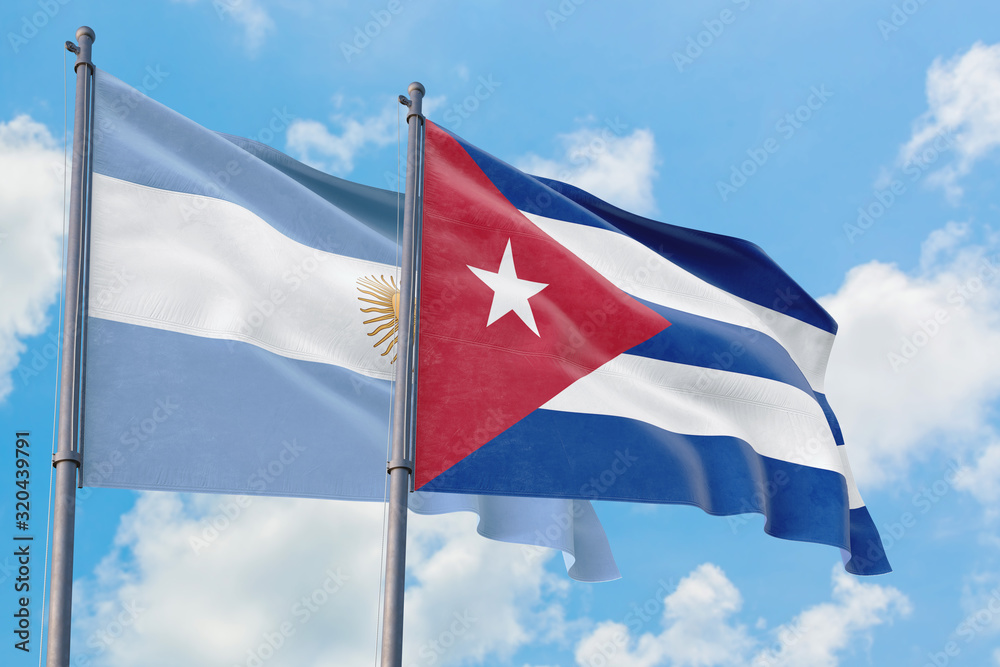 Cuba and Argentina flags waving in the wind against white cloudy blue sky together. Diplomacy concept, international relations. Cuba and Argentina flags waving in the wind against white cloudy blue sky together. Diplomacy concept, international relations.
