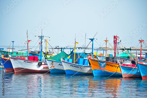 Pastel colorful fishing boats floating in the ocean in Paracas Peru