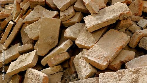 slagheap with broken bricks from a destroyed wall after a demolition or an earthquake with different forms and shapes photo