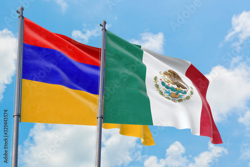 Photography Mexico and Armenia flags waving in the wind against white cloudy blue sky together