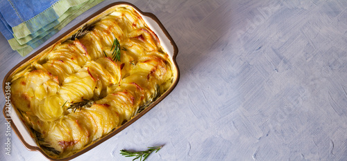 Potato gratin (with cream and butter). Scalloped potatoes or potato bake. View from above, top view. Copy space
