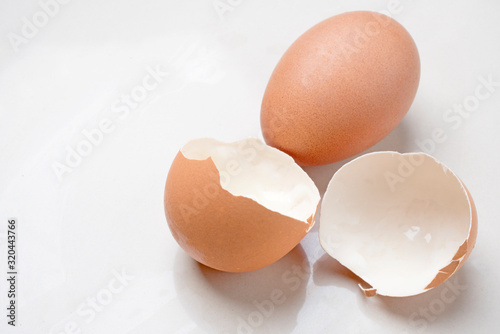 Eggshell and hen's egg on a light white marble background in the studio