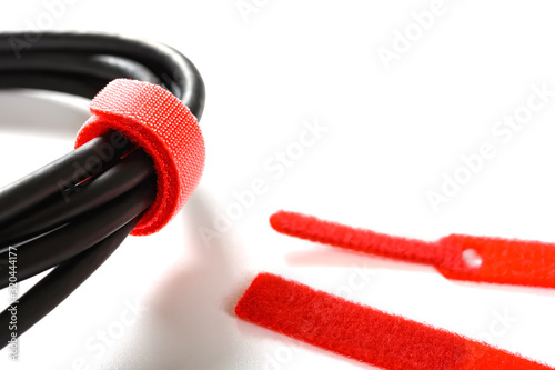 Bild auf Leinwand red velcro cable tie and cable on white