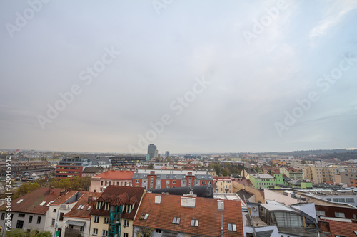 Aerial panorama of Brno, Czech Republic, with a focus on a residential suburb with skyscrapers in background, from the roofs of houses. Brno is the second biggest Czech city. photo