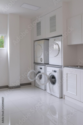 Laundry washing machine and dryer against modern appliance household in laundry room