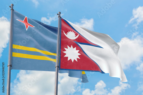 Nepal and Aruba flags waving in the wind against white cloudy blue sky together. Diplomacy concept, international relations.
