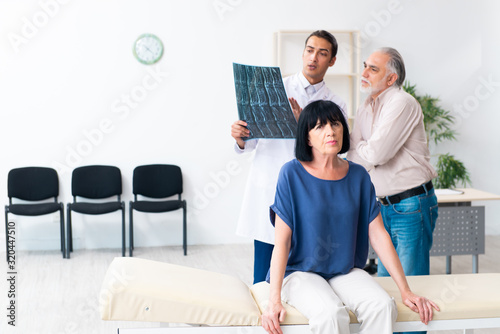 Old couple visiting young male doctor