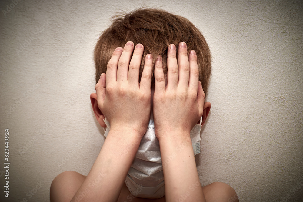 Little boy is afraid of an epidemic of a virus spreading all over the world. Face of a boy in a mask to protect against infection. Global epidemic. Fear Little boy is afraid of an epidemic of a virus spreading all over the world. Face of a boy in a mask to protect against infection. Global epidemic. Fear