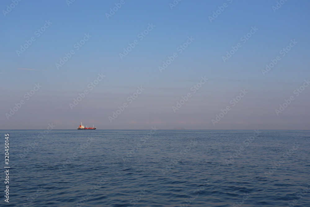 Cargo ship on the sea in a clear day and clear sky.