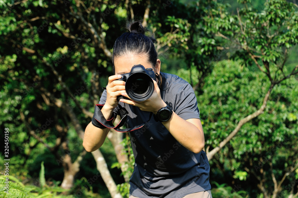 Photographer taking photo in the forest with digital camera Photographer taking photo in the forest with digital camera