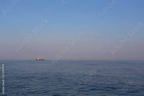 Cargo ship on the sea in a clear day and clear sky.