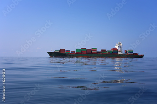 Cargo ship on the sea in a clear day and clear sky.