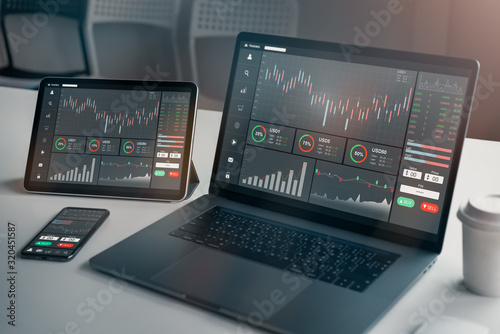 Stock exchange market concept, laptop and tablet, smartphone on the table with graphs analysis candle line in office room, diagrams on screen. photo